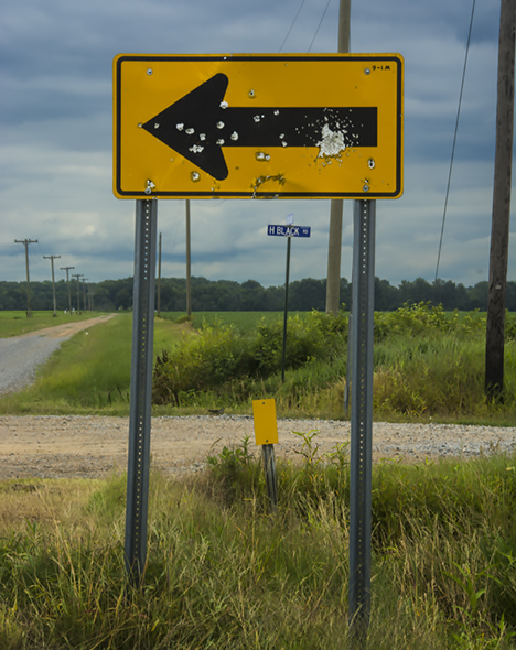Road sign with gunshot strikes